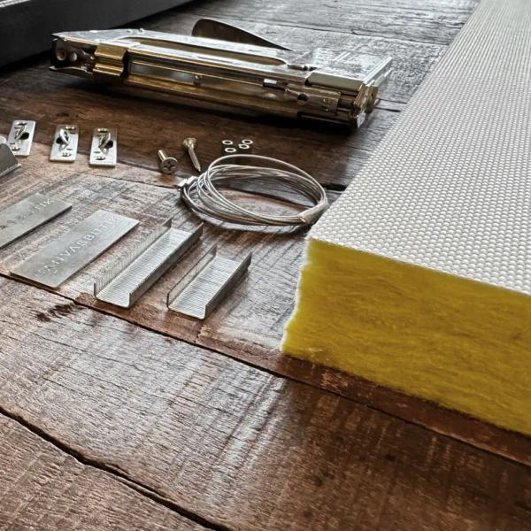 The acoustic panel’s exposed glass wool core and hanging components